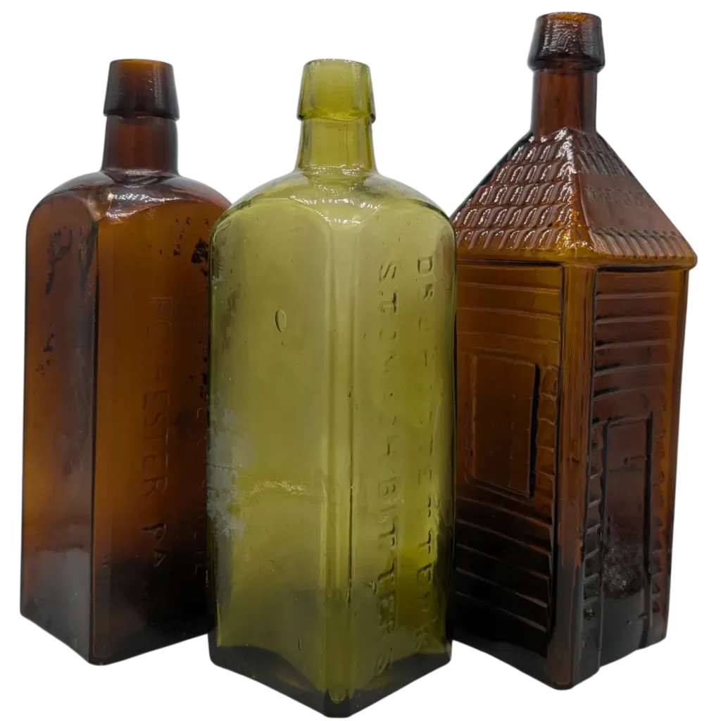A Group of Three Antique Medicine Bottles Arranged SIde by Side.