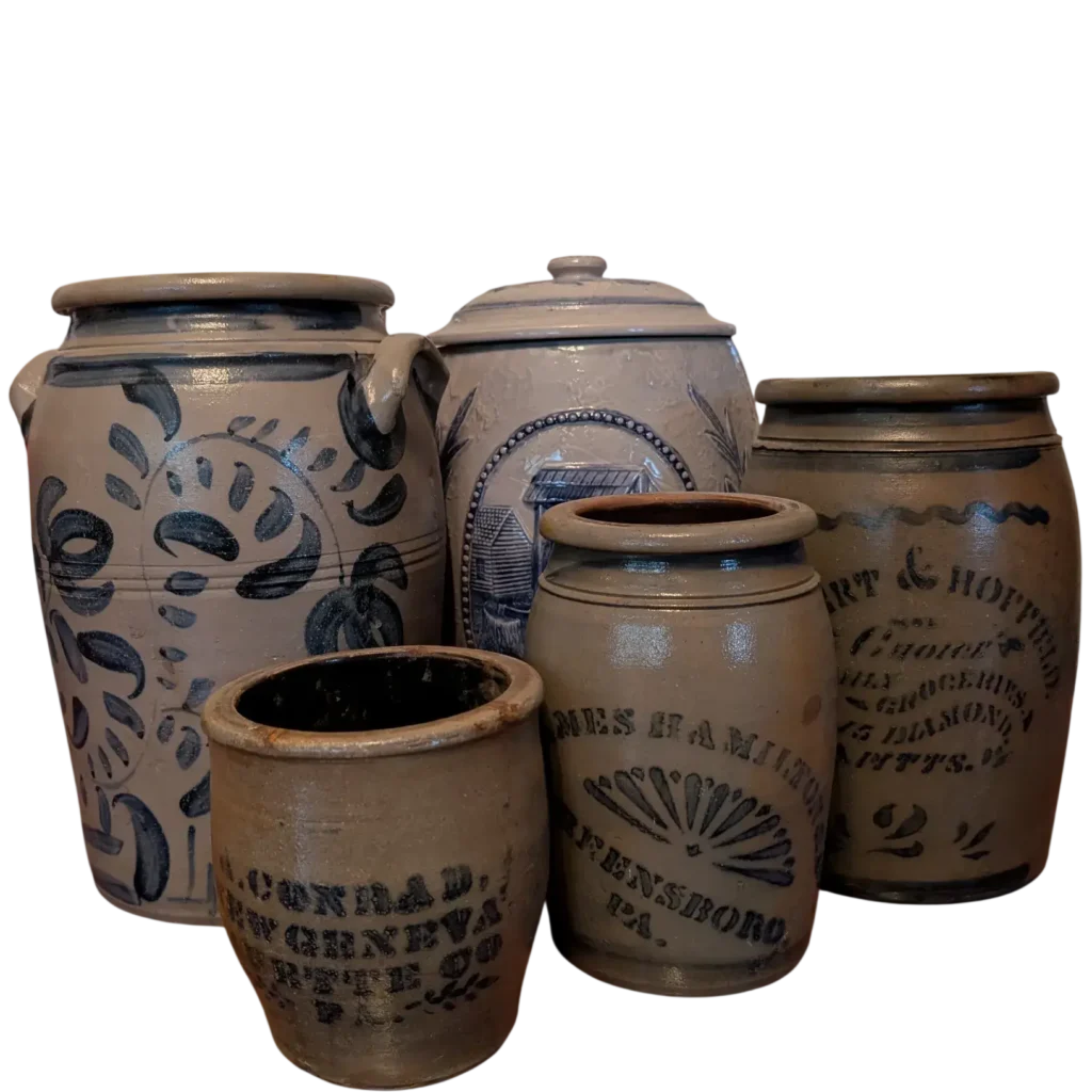 A Group of Five Antique Stoneware Crocks and Jugs with Brown and Beige Base Colors and Black and Blue Markings and Designs.